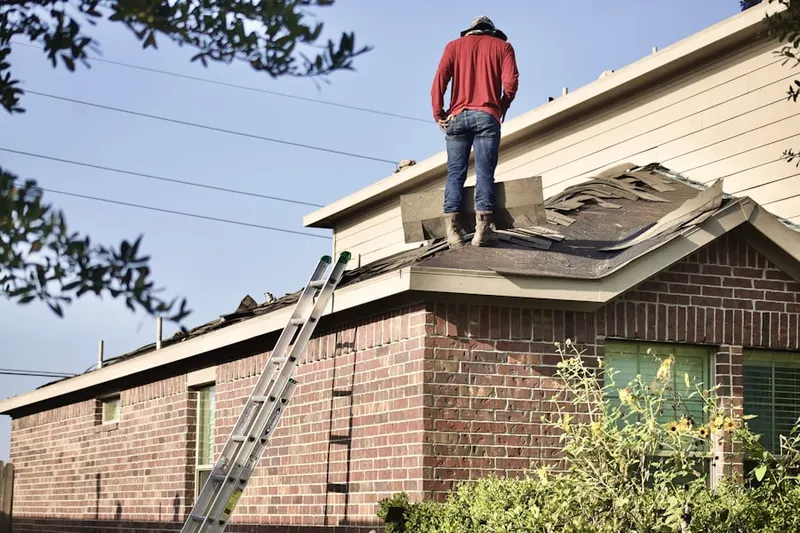 Professional roofer working on a residential roof in Franconia